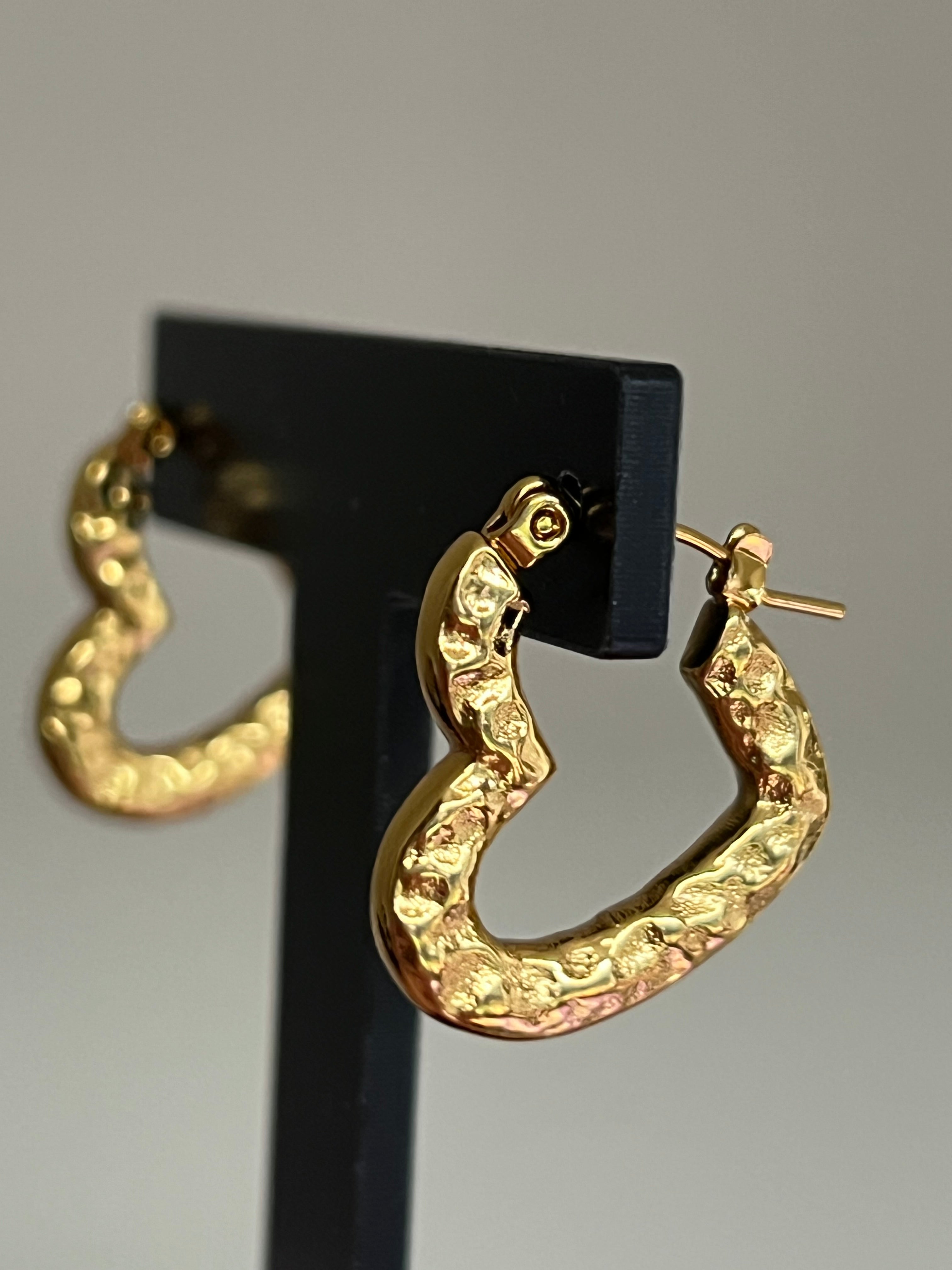 Gold hammered heart hoop earrings on black jewellery stand