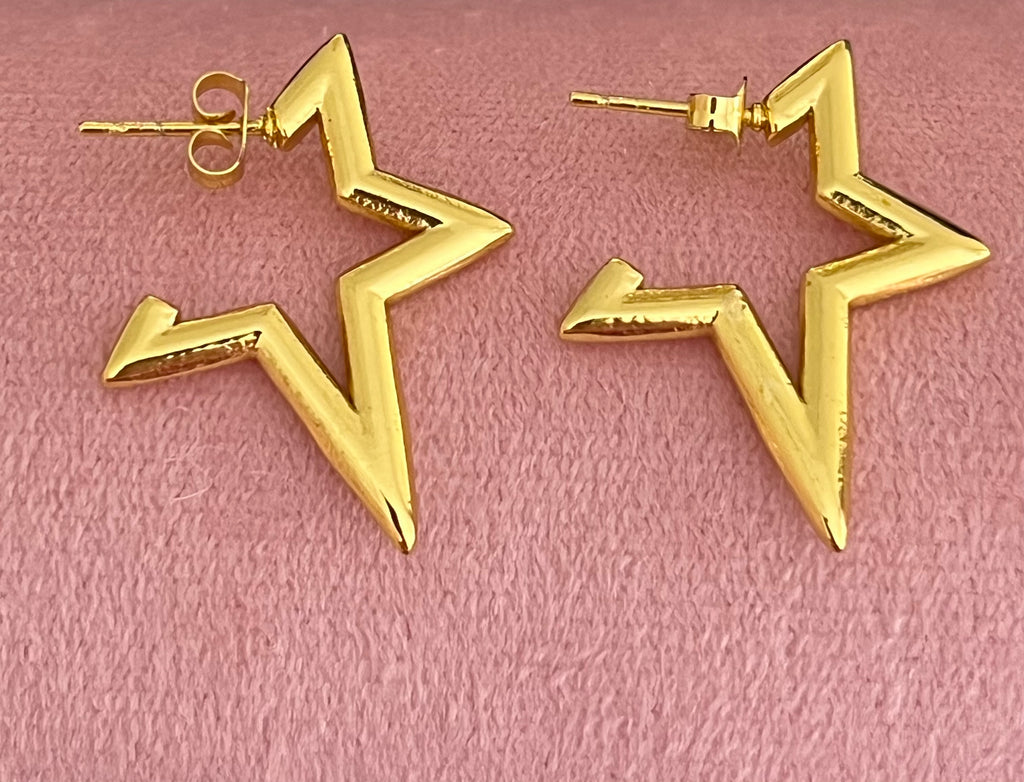 Gold star stud earrings displayed on black jewellery stand