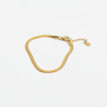 Gold herringbone bracelet on white background, product photo