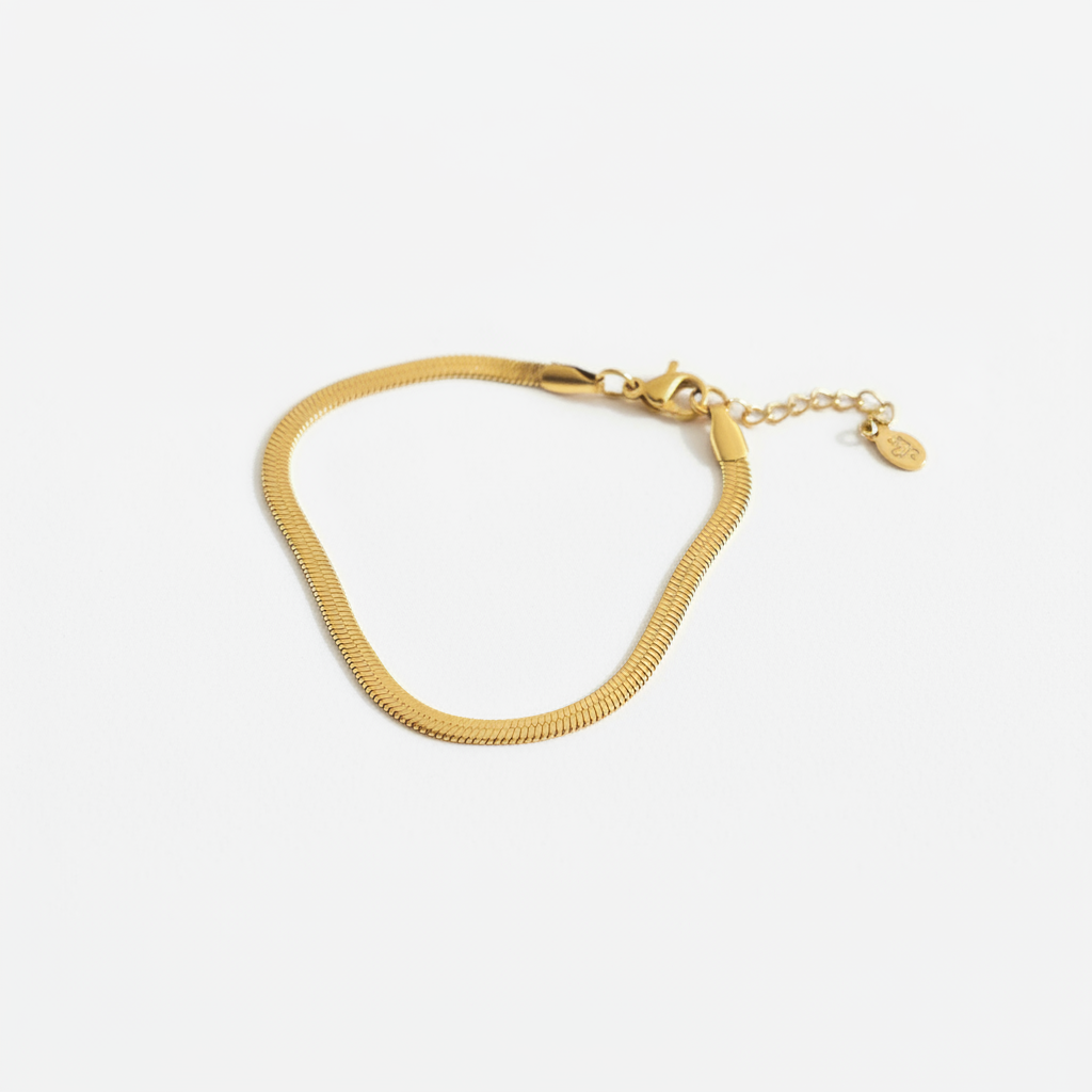 Gold herringbone bracelet on white background, product photo