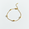 Gold bead station curb chain bracelet on white background, product photo