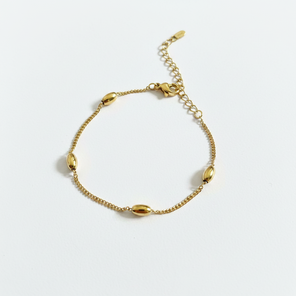 Gold bead station curb chain bracelet on white background, product photo