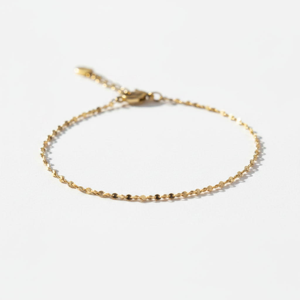 Gold flat disc chain bracelet on white background, product photo