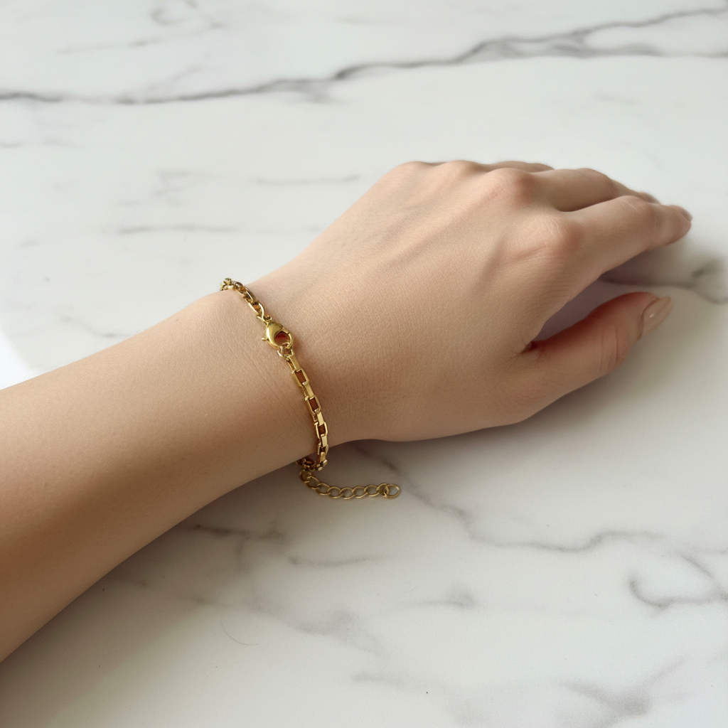 Gold paperclip chain bracelet worn on woman's wrist, lifestyle shot